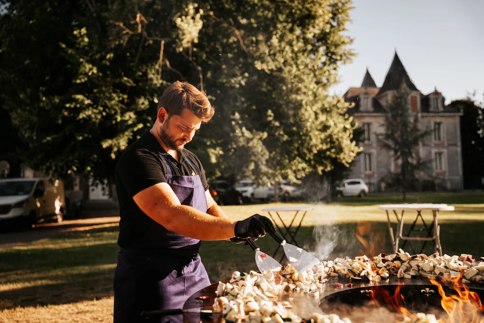 Tom, fondateur du Brasero Français, cuisine sur un brasero-plancha