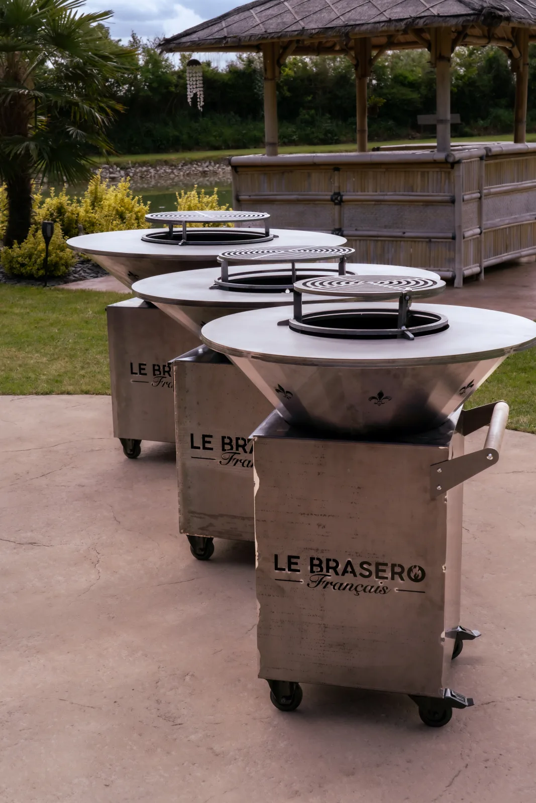 Pied en acier corten d’un brasero, ajouré du logo Le Brasero Français et monté sur roulettes à frein.